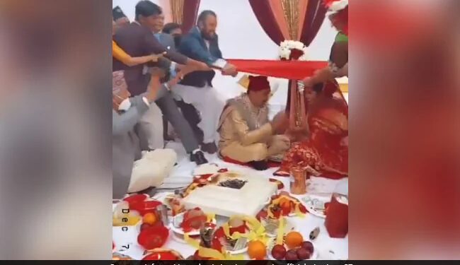 In Wedding Ceremony All The Guests Fell On The Bride And Groom, People Said – Very Stupid Custom See Viral Video – शादी की रस्म के बीच हुआ कुछ ऐसा, धड़-धड़ाकर दूल्हा-दुल्हन के ऊपर गिरे सभी मेहमान, लोग बोले- बड़ा बेहूदा रिवाज़ है