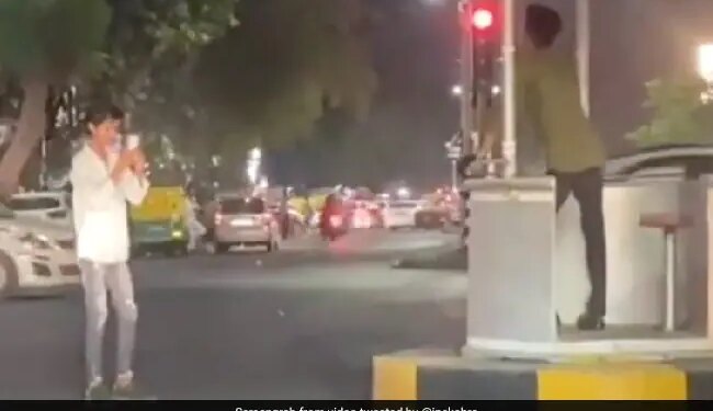 IPS Officer Shares Video Of Two Friends Clicking Photos At Traffic Signal Internet Says Hadh Hai – ट्रैफिक सिग्नल पर खड़े होकर सेल्फी ले रहे थे दो दोस्त, रेड लाइट पर खूब दिए पोज़, IPS ने कही ये बात