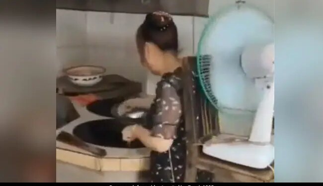 Woman Did Amazing Jugaad In Kitchen Tied A Chair Around Her Waist And Put A Table Fan On It Watch Viral Video – किचन में गर्मी से बचने के लिए महिला ने किया गजब जुगाड़, कमर में बांधी कुर्सी और लगा लिया टेबल फैन