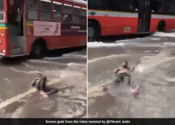 Man Lying Comfortably On A Waterlogged Street Amid Mumbai Rains Internet Says Feeling Maldives In Malad See Viral Video – मुंबई की बारिश में पानी से भरी सड़क पर आराम से लेटकर चिल करते दिखा शख्स, लोग बोले