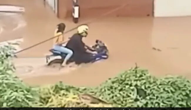 Boy Drive Bike On Flooded Road With Girlfriend People Said This Is Called The Power Of True Love See Viral Video – गर्लफ्रेंड को बैठाकर बाढ़ से भरी सड़क पर दौड़ाई बाइक, लोग बोले