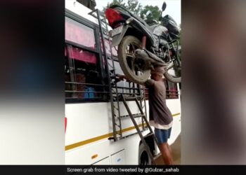 Man Put The Motorcycle On His Head Climbs On Bus Roof Without Holding It Internet Call Him Real Bahubali See Viral Video – शख्स ने सिर पर रखी मोटरसाइकिल, बिना हाथों से पकड़े बस पर लेकर चढ़ गया, लोग बोले