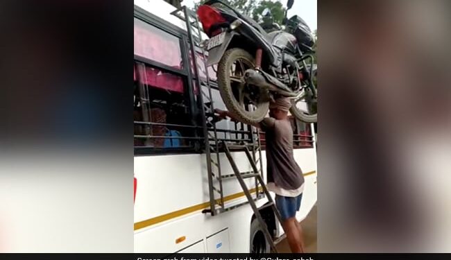 Man Put The Motorcycle On His Head Climbs On Bus Roof Without Holding It Internet Call Him Real Bahubali See Viral Video – शख्स ने सिर पर रखी मोटरसाइकिल, बिना हाथों से पकड़े बस पर लेकर चढ़ गया, लोग बोले