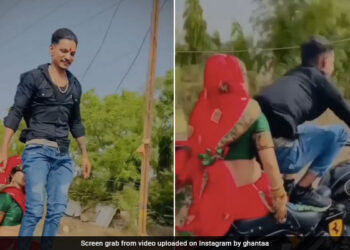 Husband Doing Stunt While Wife Sitting On His Bullet Left The Handle And Stood On The Seat See Shocking Video – पत्नी को बुलेट पर बैठाकर ‘खतरों के खिलाड़ी’ बना शख्स, हैंडल छोड़ सीट पर खड़ा हो गया, लोग बोले
