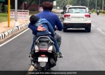 Father Prevents Son From Falling Off A Moving Scooter: Man Holding His Child From Falling Off A Moving Scooter Moves