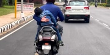 Father Prevents Son From Falling Off A Moving Scooter: Man Holding His Child From Falling Off A Moving Scooter Moves