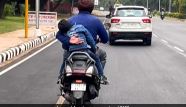 Father Prevents Son From Falling Off A Moving Scooter: Man Holding His Child From Falling Off A Moving Scooter Moves